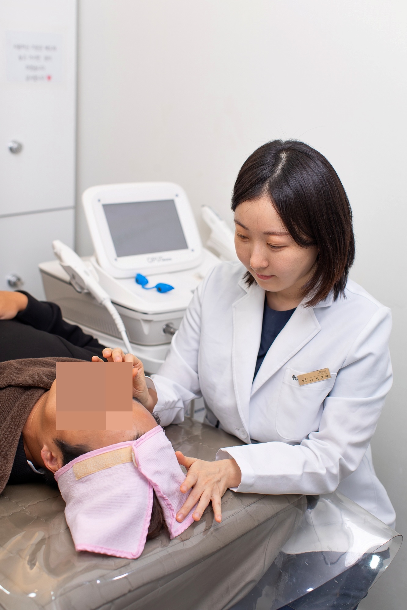 환자의 이마 주변을 살피며 시술을 준비하는 모습